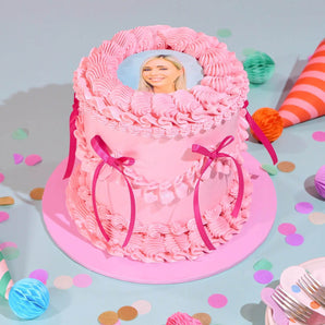 Vintage Photo Cake by Crumbs & Doilies with pink buttercream, edible photo topper, and ribbon decoration.